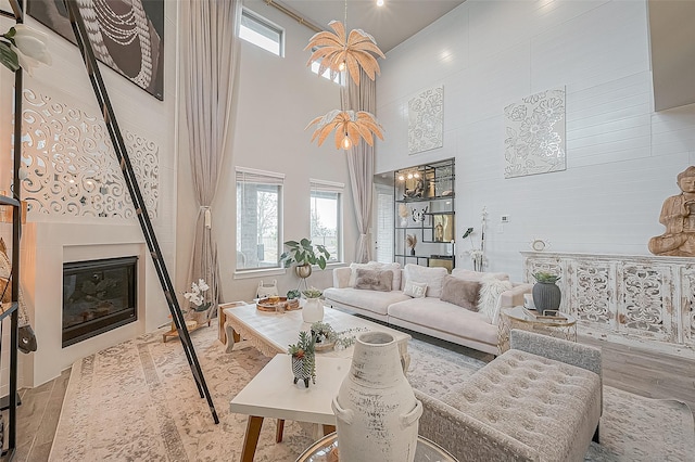 living room featuring light wood-type flooring and a towering ceiling