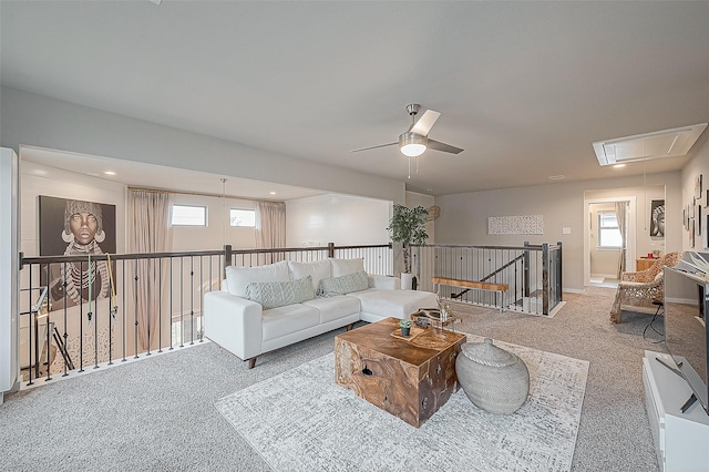 carpeted living room with ceiling fan