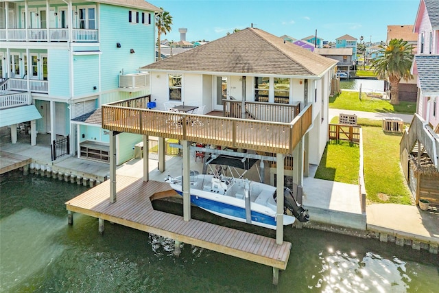 rear view of property featuring a water view and a lawn