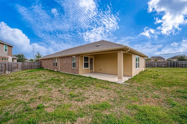 rear view of property featuring a yard and a patio area