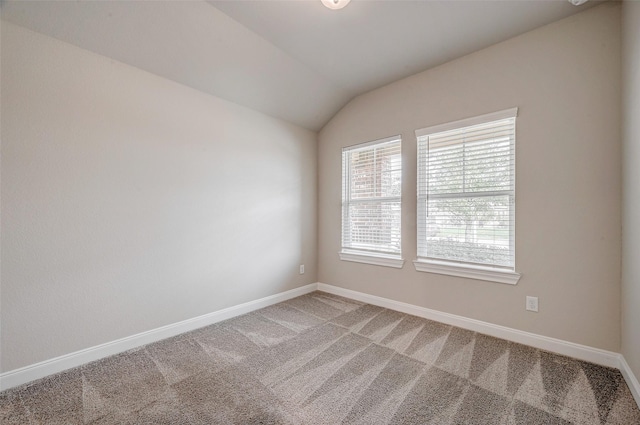 carpeted empty room with lofted ceiling