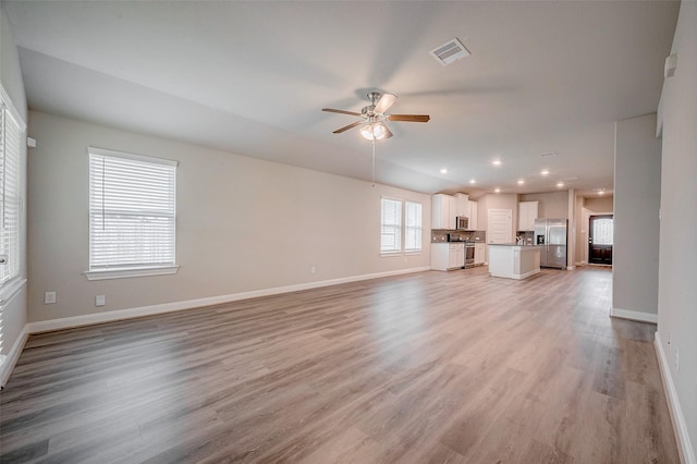 unfurnished living room featuring ceiling fan and light hardwood / wood-style floors