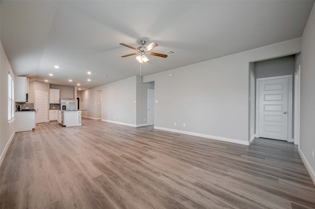 unfurnished living room featuring light wood-type flooring and ceiling fan