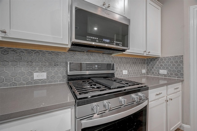 kitchen featuring decorative backsplash, stainless steel appliances, and white cabinets