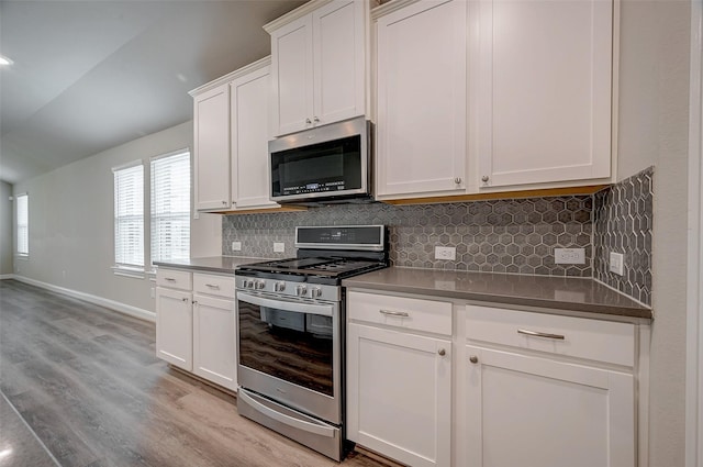 kitchen featuring backsplash, white cabinets, stainless steel appliances, and light hardwood / wood-style flooring