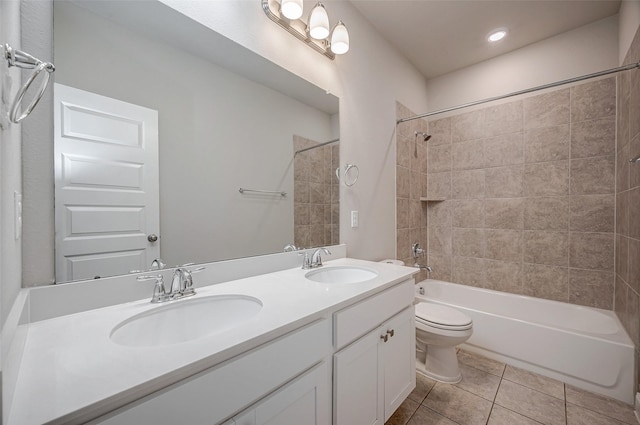 full bathroom with toilet, vanity, tile patterned flooring, and tiled shower / bath