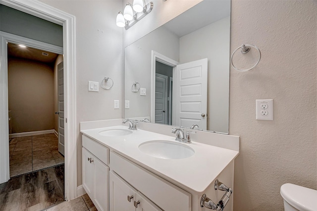 bathroom with wood-type flooring, vanity, and toilet