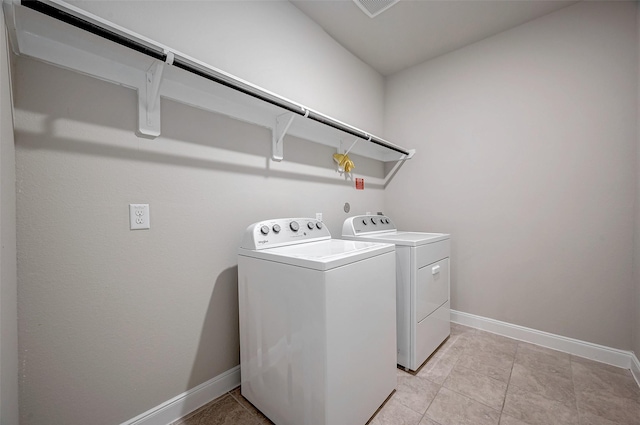 clothes washing area with light tile patterned floors and washing machine and clothes dryer