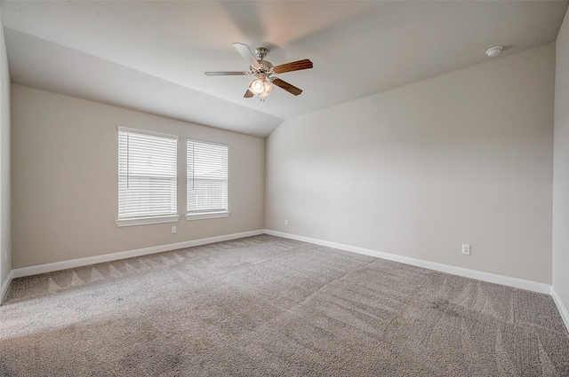 carpeted spare room featuring lofted ceiling and ceiling fan