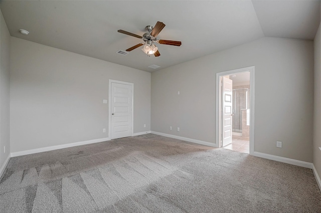 carpeted spare room featuring lofted ceiling and ceiling fan