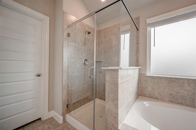 bathroom with shower with separate bathtub and tile patterned floors