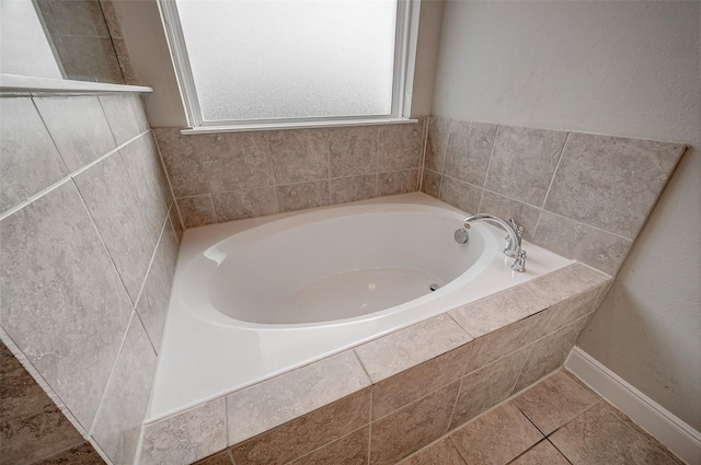 bathroom with tile patterned flooring and tiled tub