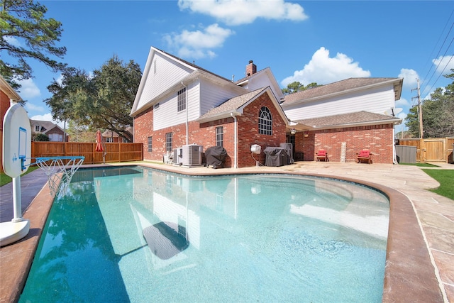 view of pool with area for grilling, fence, a fenced in pool, and central air condition unit