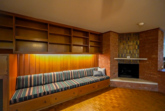 unfurnished living room with a brick fireplace and light parquet floors