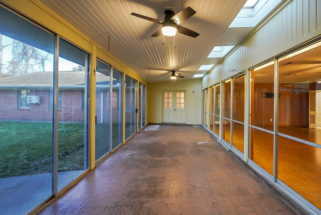 unfurnished sunroom with ceiling fan and a skylight