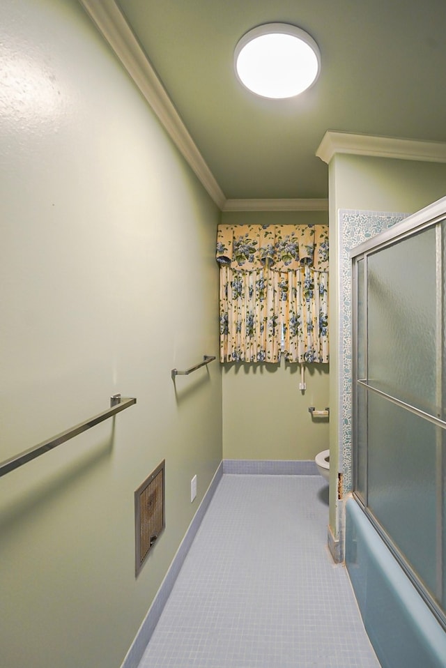 bathroom with crown molding, tile patterned flooring, shower / bath combination with glass door, and toilet