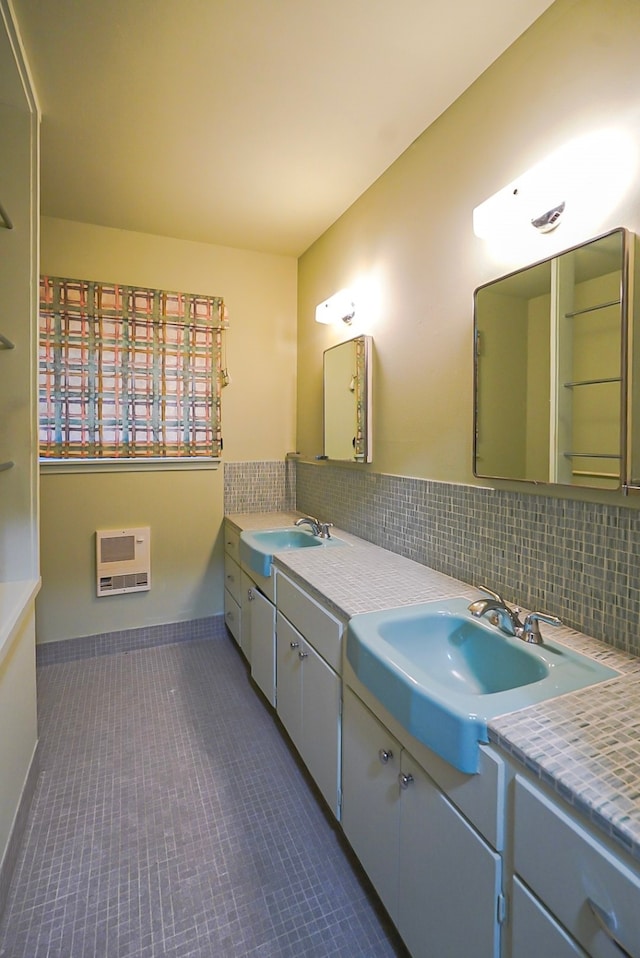 bathroom featuring heating unit, tile patterned floors, vanity, and tasteful backsplash