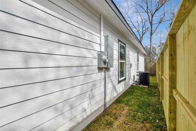 view of side of home featuring a yard and central AC unit