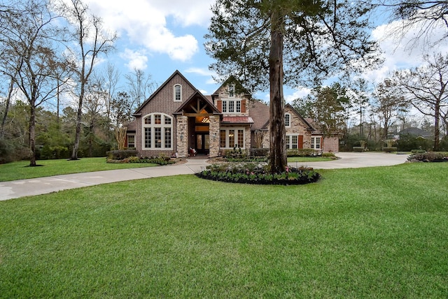 view of front of property with stone siding, a front lawn, and concrete driveway