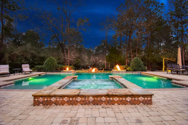 view of pool featuring an outdoor fire pit, a patio area, and a pool with connected hot tub