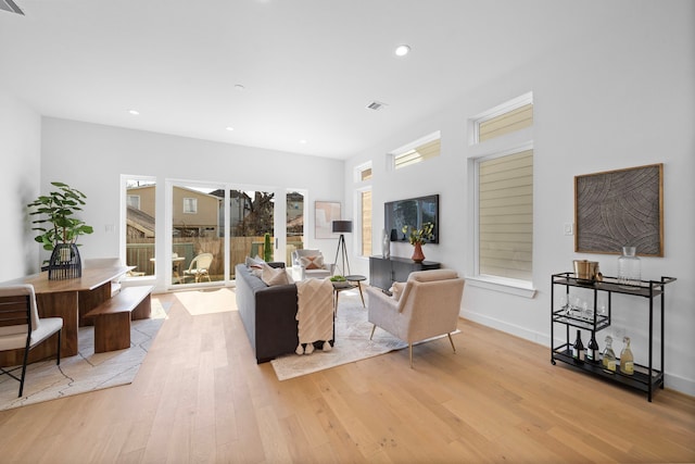 living room with baseboards, recessed lighting, visible vents, and light wood-style floors