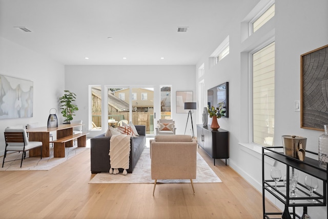 living room featuring light wood-style floors, recessed lighting, a healthy amount of sunlight, and visible vents