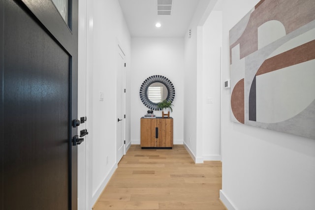 hall with light wood-type flooring, baseboards, visible vents, and recessed lighting