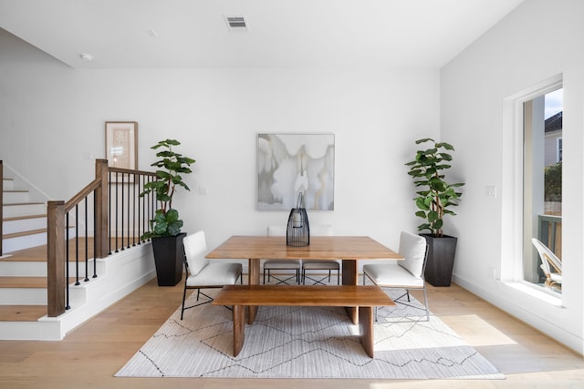 dining space with stairway, visible vents, and light wood-style floors