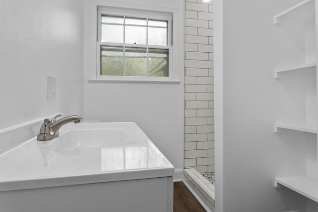 bathroom featuring a tile shower, vanity, and hardwood / wood-style floors