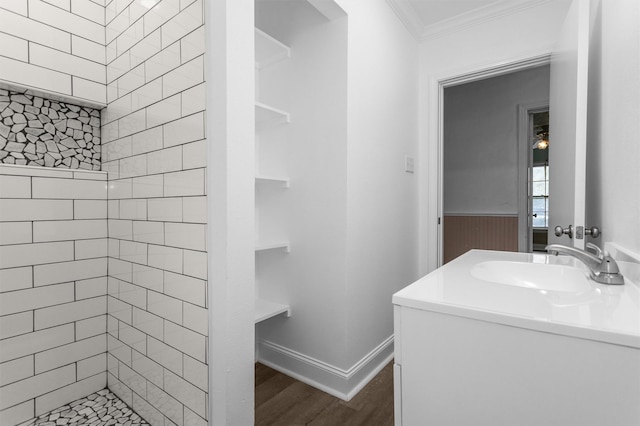 bathroom featuring ornamental molding, a tile shower, vanity, and hardwood / wood-style floors