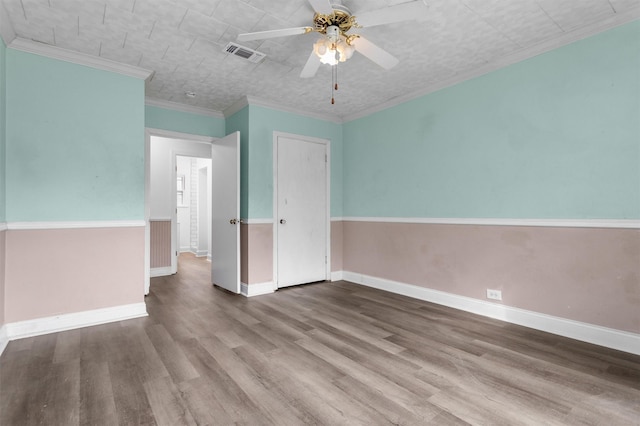 spare room featuring ceiling fan, wood-type flooring, and ornamental molding