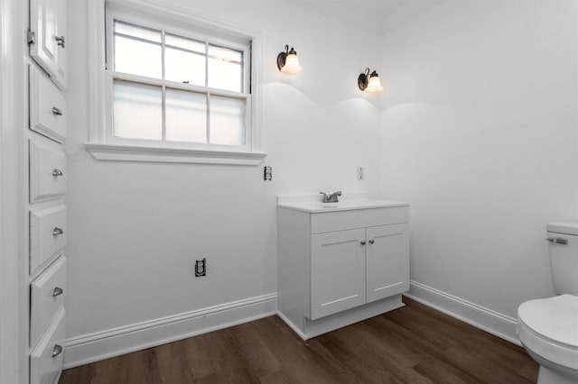 bathroom with hardwood / wood-style floors, vanity, and toilet