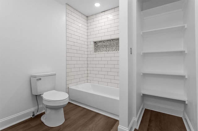 bathroom featuring hardwood / wood-style floors, toilet, and tiled shower / bath combo