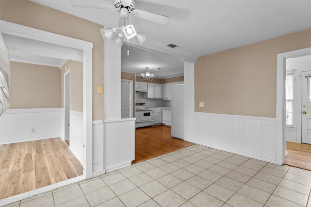 kitchen with ceiling fan with notable chandelier, light tile patterned flooring, white appliances, and white cabinetry