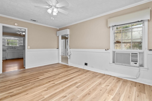 spare room featuring a textured ceiling, crown molding, ceiling fan, and light hardwood / wood-style flooring