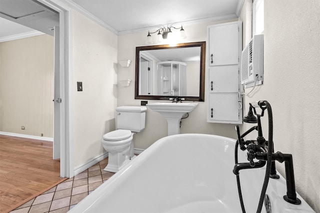 bathroom featuring a tub, tile patterned floors, toilet, and ornamental molding