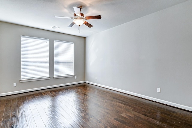 unfurnished room featuring ceiling fan, dark wood finished floors, visible vents, and baseboards