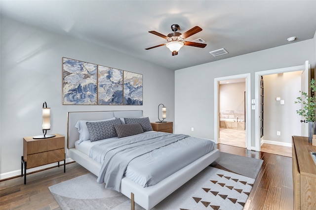 bedroom featuring ensuite bathroom, ceiling fan, dark wood-style flooring, visible vents, and baseboards