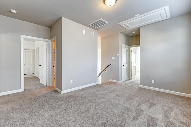 empty room with visible vents, carpet, attic access, and baseboards