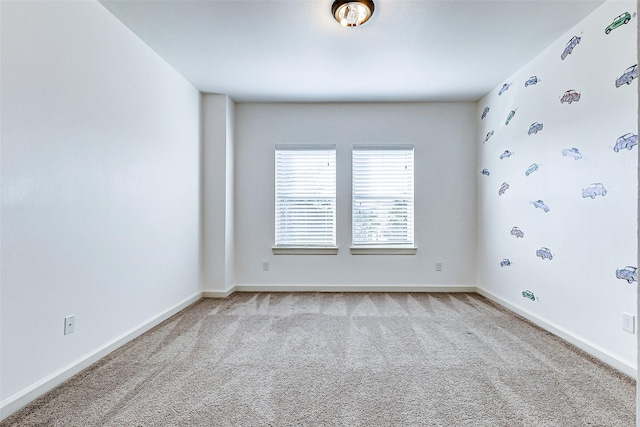 carpeted empty room featuring baseboards