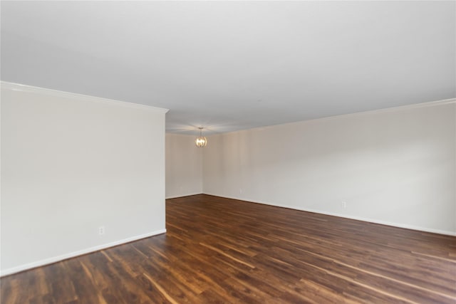 unfurnished room with ornamental molding, dark hardwood / wood-style floors, and an inviting chandelier