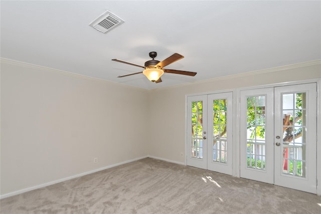 carpeted empty room featuring ceiling fan, ornamental molding, and french doors