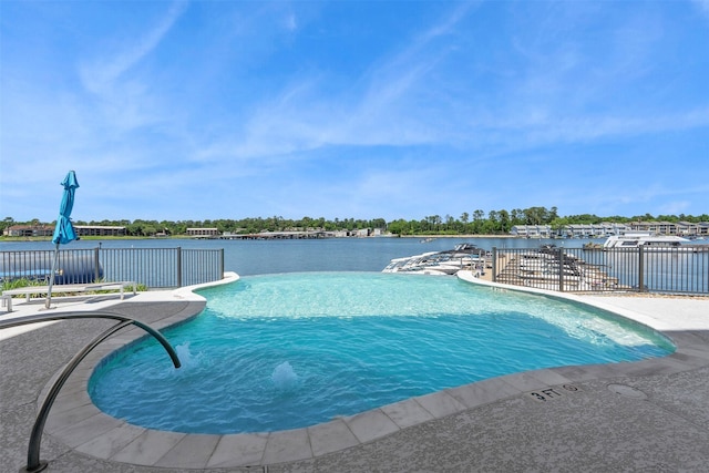 community pool featuring a patio, a water view, and fence