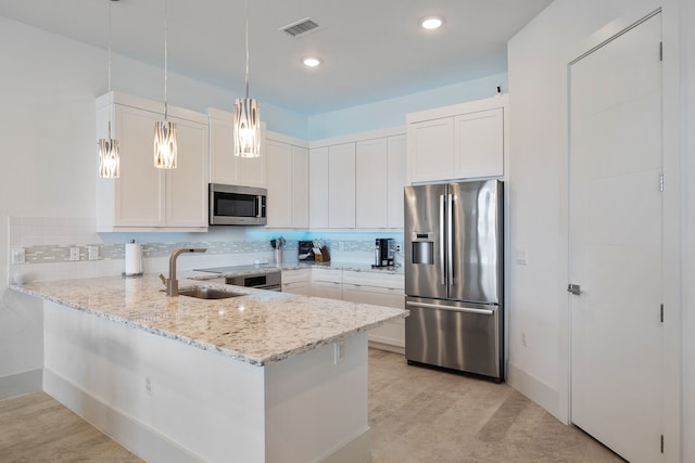 kitchen featuring a peninsula, a sink, visible vents, appliances with stainless steel finishes, and tasteful backsplash