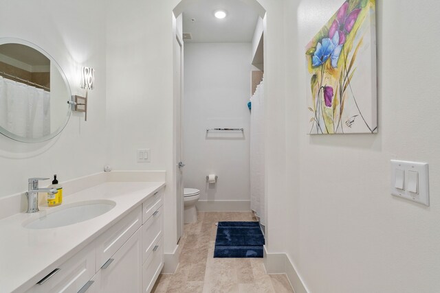 bathroom featuring toilet, baseboards, a shower with shower curtain, and vanity