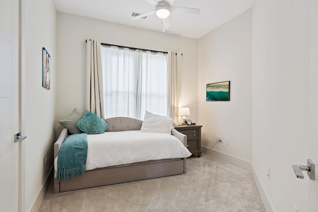 carpeted bedroom with a ceiling fan, visible vents, and baseboards