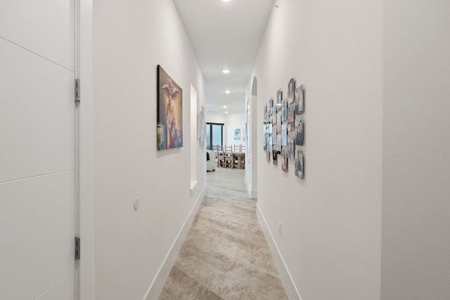 hall featuring baseboards and recessed lighting