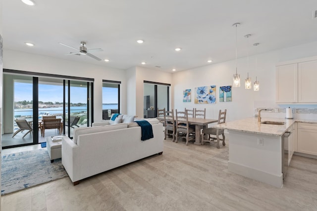 living area with ceiling fan, light wood-type flooring, and recessed lighting