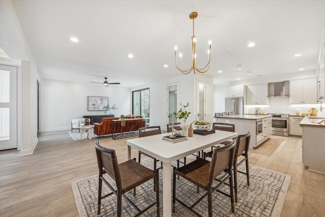 dining room featuring light wood-style flooring, baseboards, ceiling fan with notable chandelier, and recessed lighting