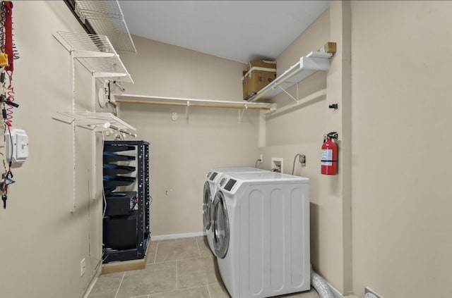 clothes washing area featuring light tile patterned floors and washing machine and clothes dryer